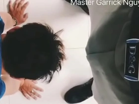 A subservient Asian man satisfies his superior in an office setting.