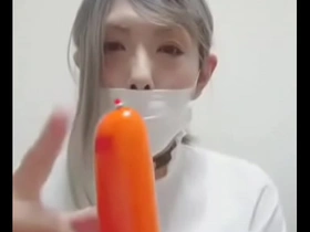 Chimi Risa, a femboy, enjoys eating sausages while washing dishes.